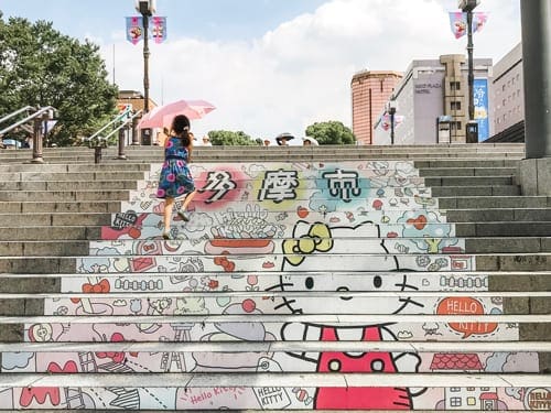 A young girl walks up Hello Kitty-themed stairs in Tokyo, Japan.