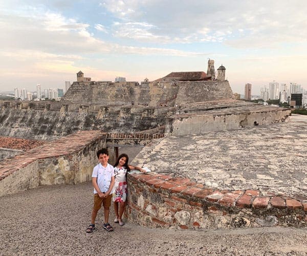 Two kids stand together in front of Castillo San Felipe in Cartagena, Colombia.
