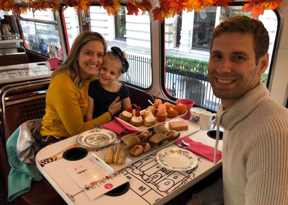 A mom, dad, and toddler daughter enjoy tea aboard the B Bakery Afternoon’s Tea Bus Tour.