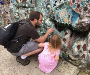 Father and daughter admiring colorful mosaic tiles in the Magic Garden of Philadelphia