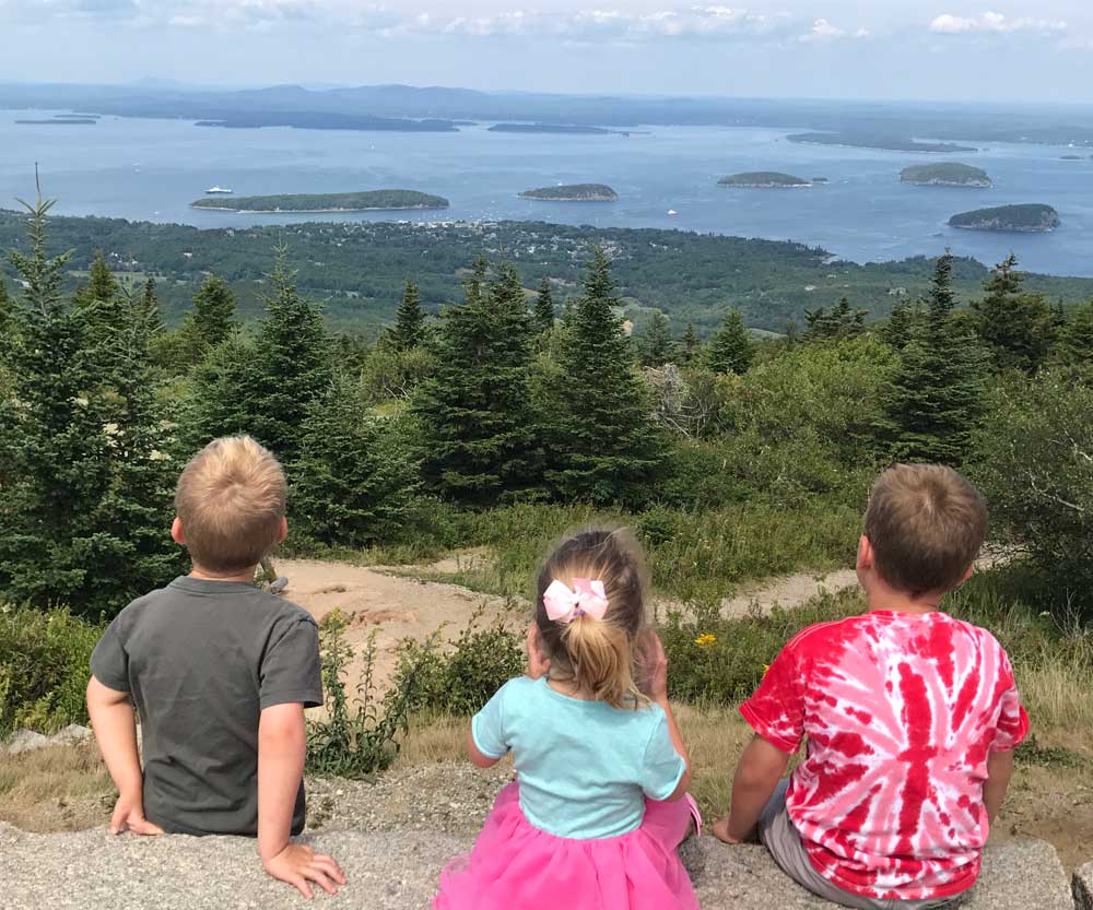 Three children on a hike enjoying the view at Acadia National Park