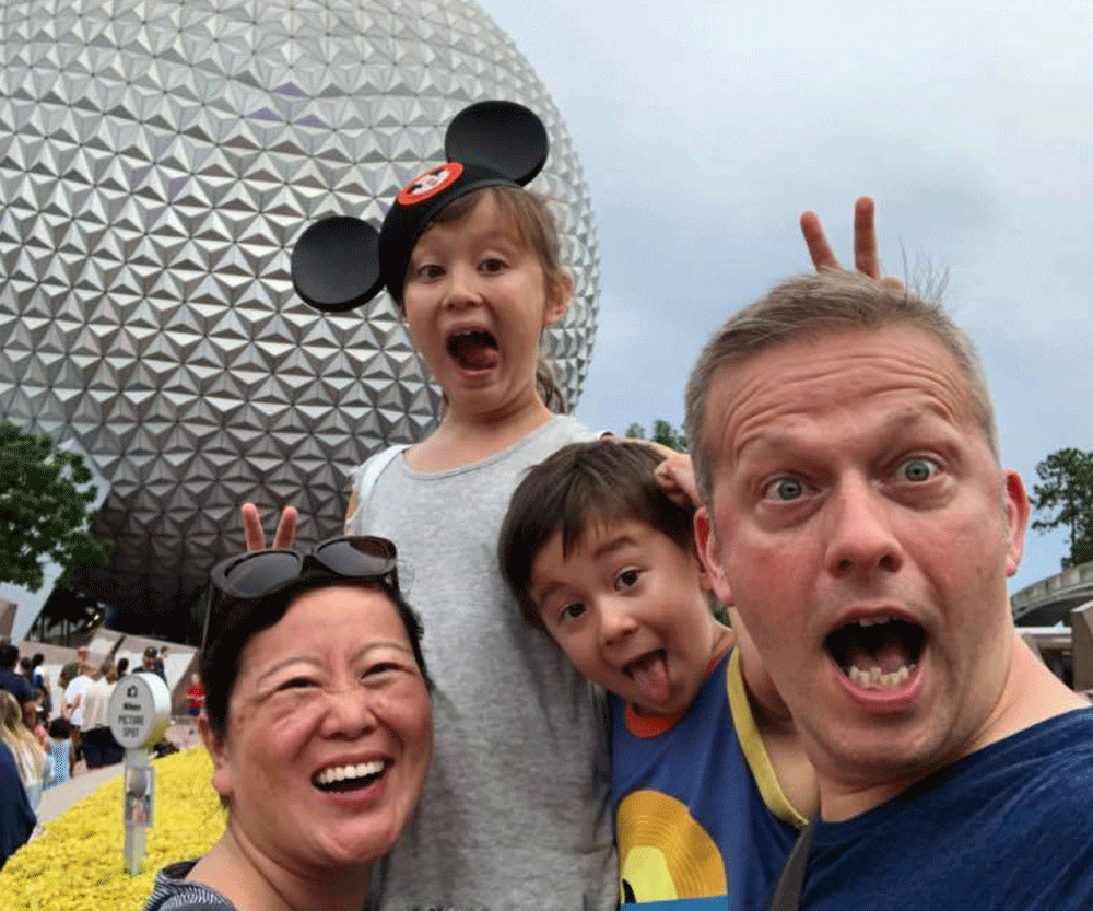 A family posing in Epcot, Disney.
