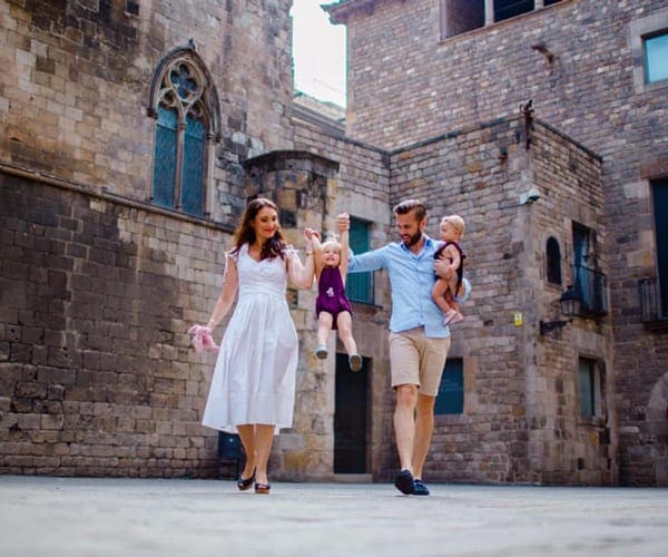 Mom and dad holding two kids while exploring La Sagrada Familia in Barcelona.