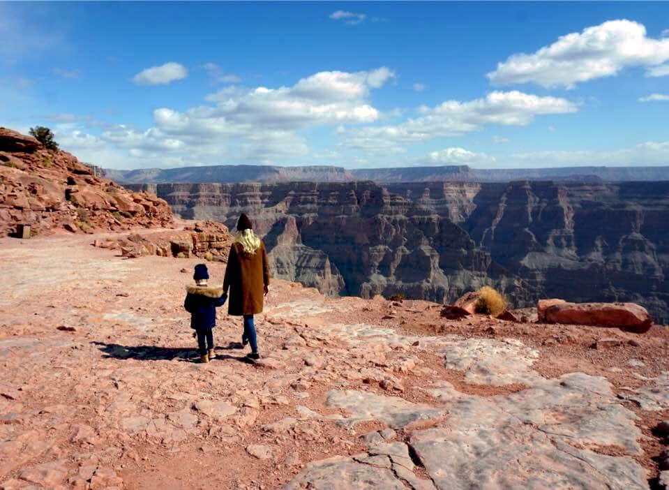 Mother and child walking in winter jackets in Grand Canyon with amazing views. Sedona is a great option for spring break family destinations.