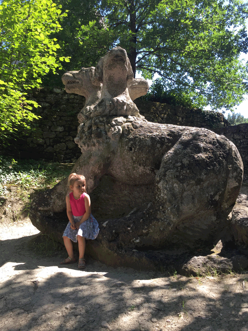 Young girl playing in Monster Park in Bomarzo Italy