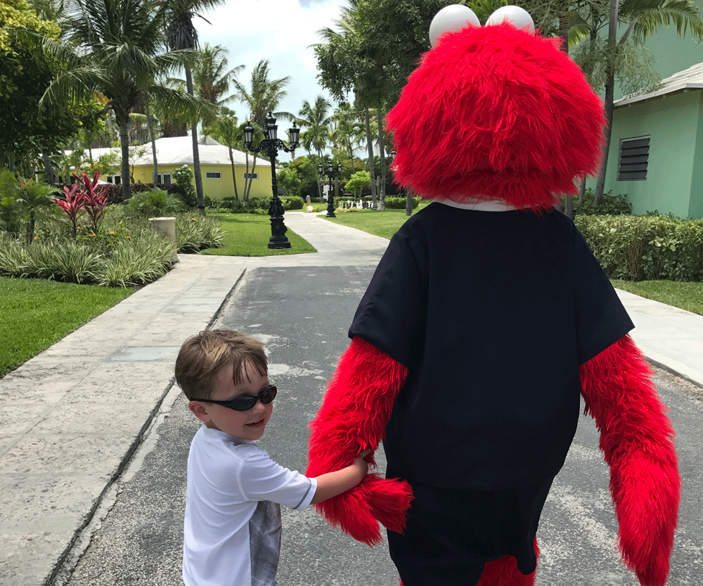 Little boy holding hand of Elmo in beaches turks caicos