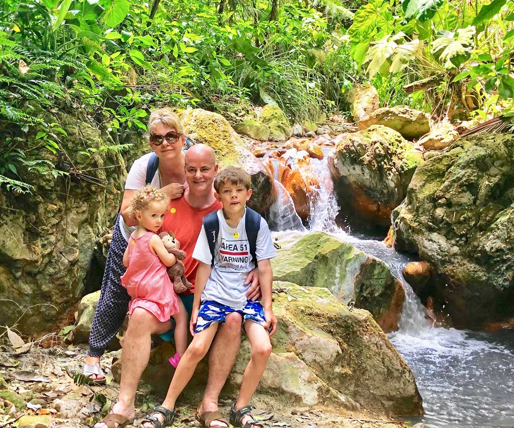 Family in St. Lucia hiking near waterfall