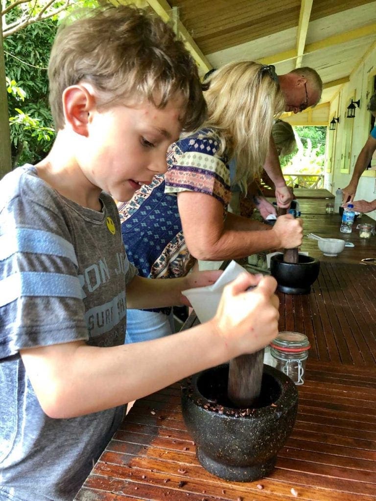 Parents and child participating in family resort activities by making chocolate in St. Lucia
