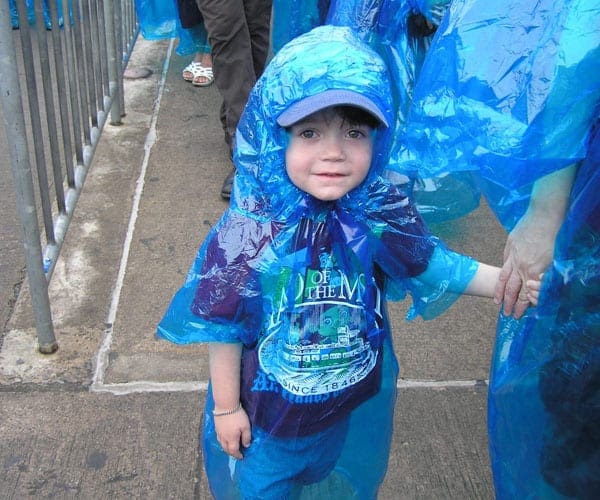 A little boy wearing a rain poncho on a Niagara Falls tour for families.