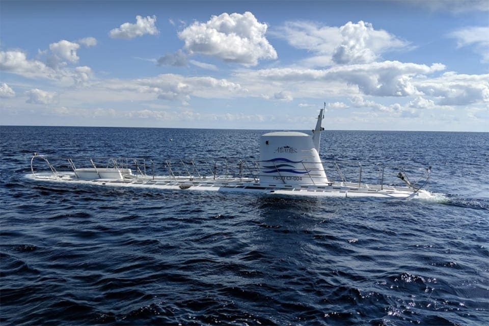 The top of the Atlantis Submarine emerges from the water on a clear day.