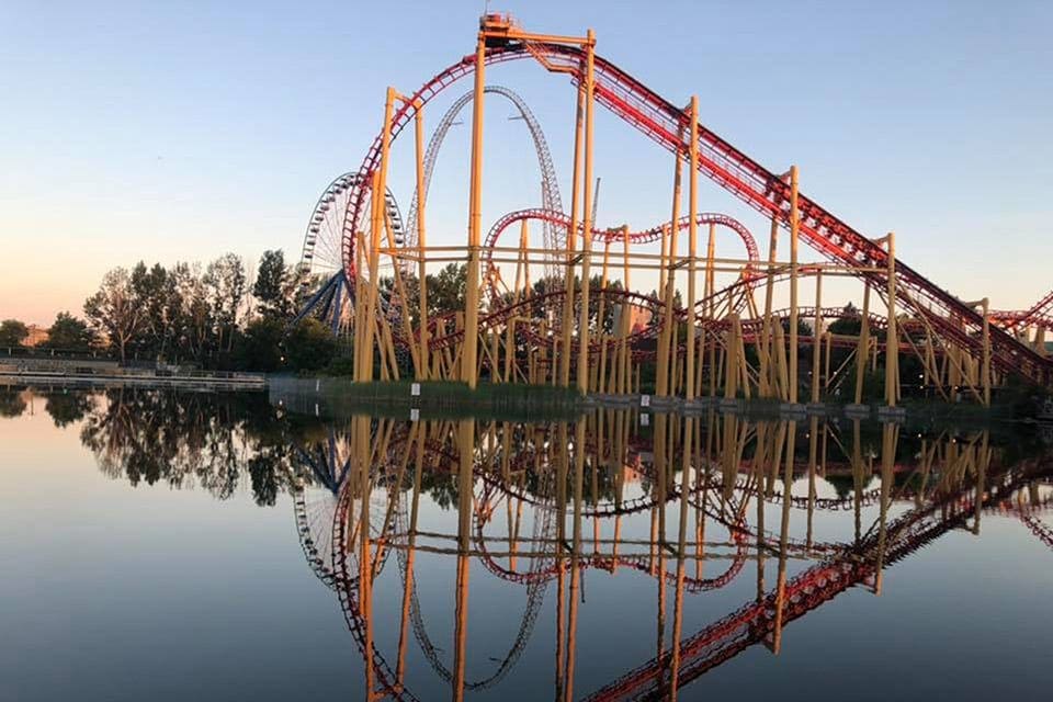 A large roller coaster stands over a pond at La Ronde Amusement Park in Montreal.