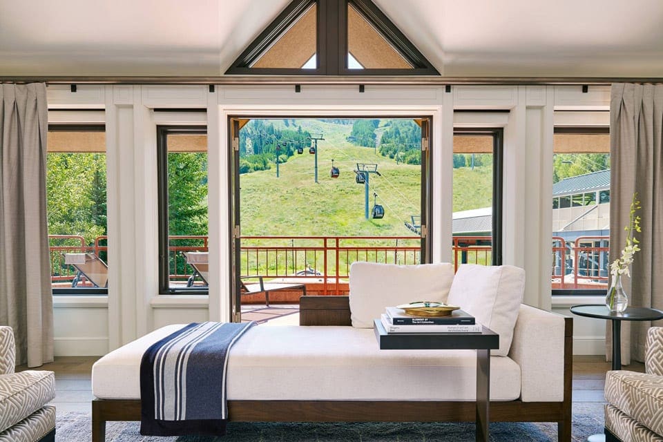 Inside a lush suite at The Little Nell with a view of the mountain and ski lift out the window during the summer.