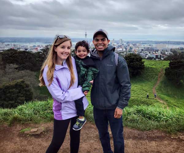 Mom holding a little boy in her arms and dad next to them in New Zealand.