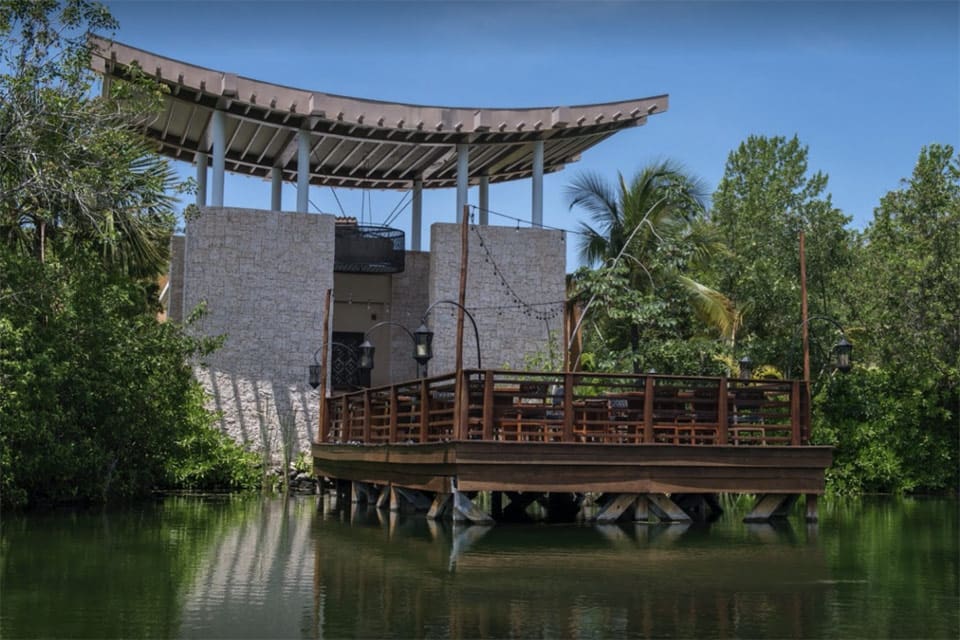 The patio seating outside of Saffron, one of the best restaurants in Playa del Carmen with kids, which is a dock resting on tranquil waters.