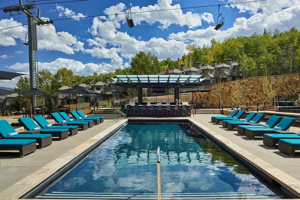 The intimate outdoor pool at Viceroy Snowmass, with a ski lift moving overhead during the summer.