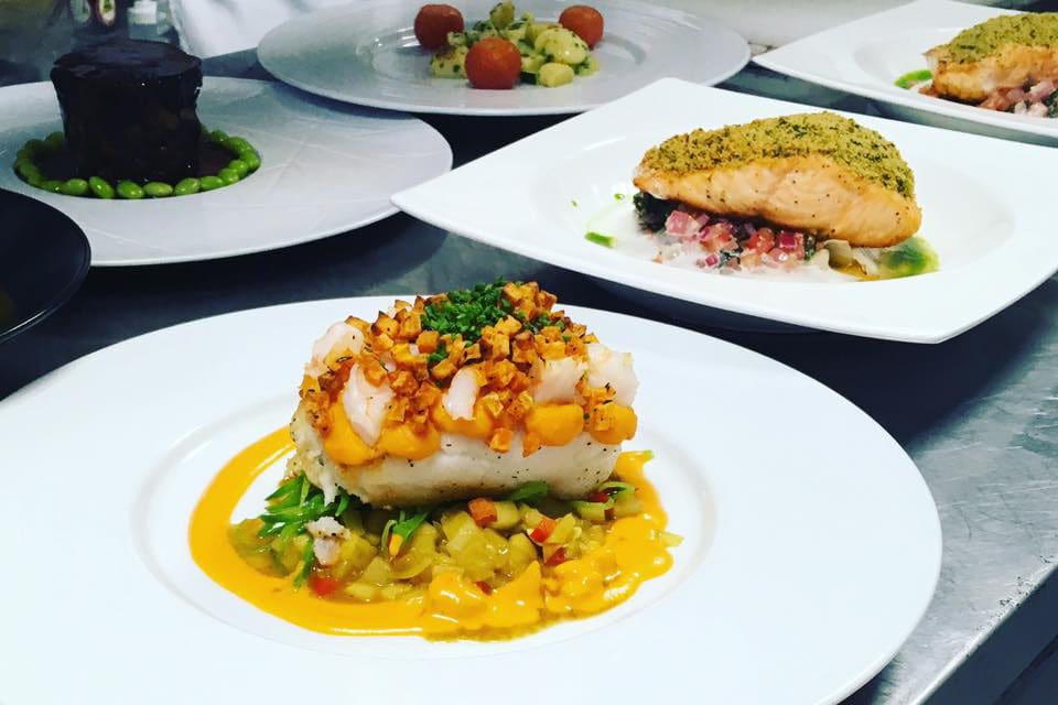 A well-plated portion of food, featuring a filet of fish over vegetables at Wilhelmina Restaurant