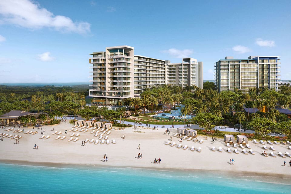 Kimpton Seafire Resort + Spa from the ocean view, featuring an expansive beach and large buildings on the grounds.