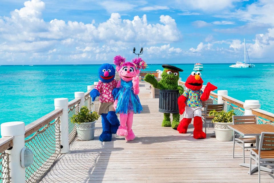 Several Sesame Street characters walk along a dock at Beachs Turks & Caicos.