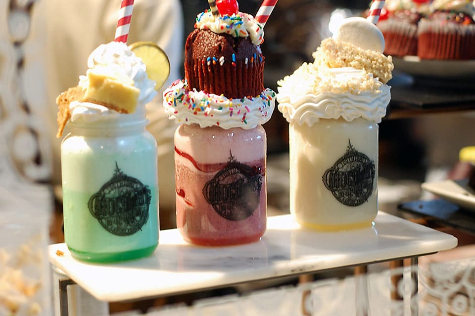 Three oversized malts in mason jars line a table at Black Tap, one of the most unique New York City restaurants with Kids.