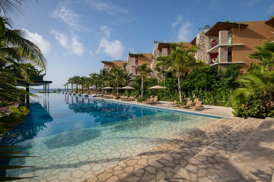 The edge of the resort buildings at Hotel Xcaret, flanking one side of the pool.