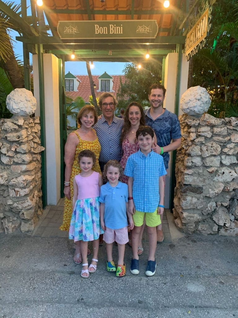 A family of seven standing in front of Papamiento, one of the best restaurants in Aruba for families.