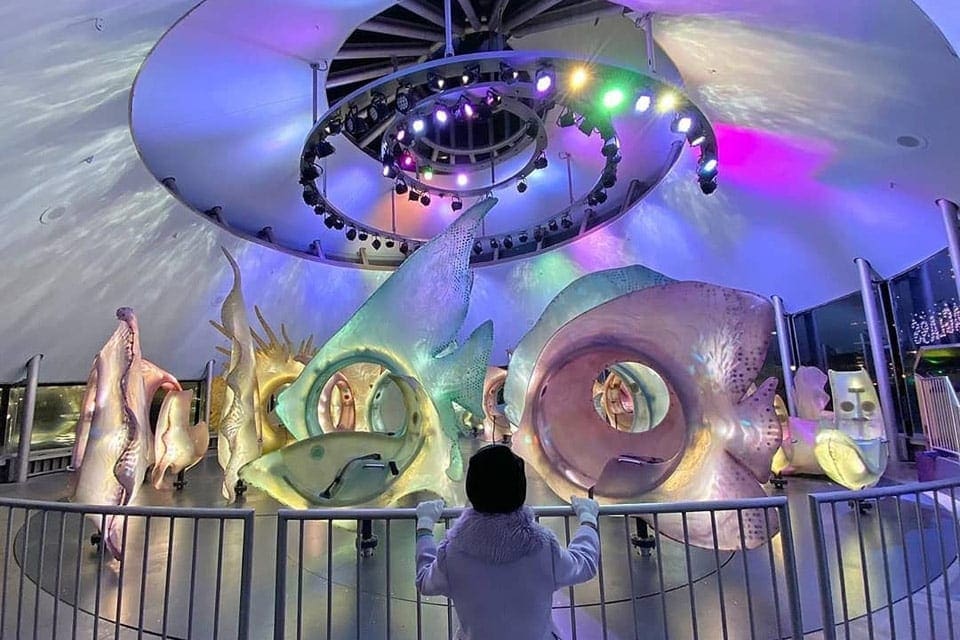 A child overlooking the Seaglass Carousel in Lower Manhattan, one of the best places to visit on a Northeast road trip with kids. 