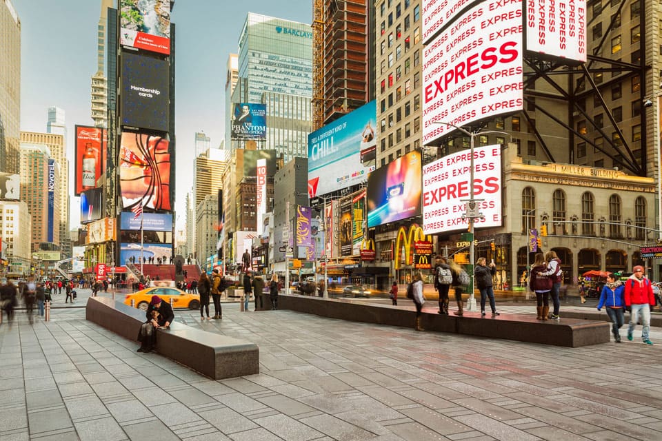 Times Square busy with people in New York City, one of the best places to travel with your mom.