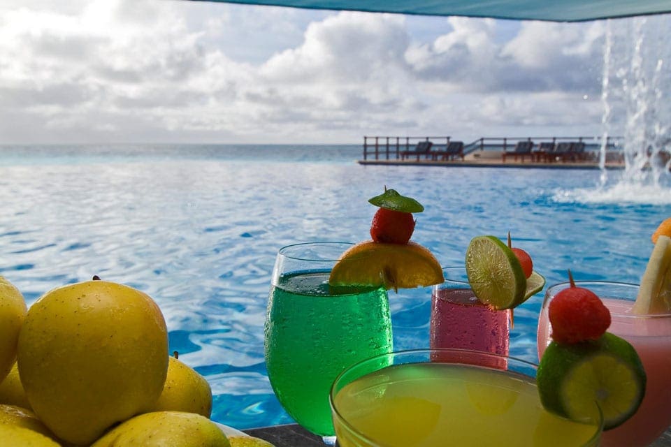 An array of fruit and cocktails overlooking the ocean at Restaurante Benazuza, one of the best restaurants in Cancun with kids.