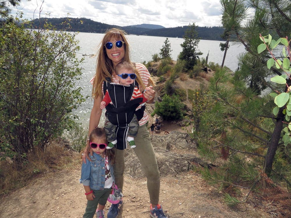 Mom with baby and a toddler in  front of a lake 