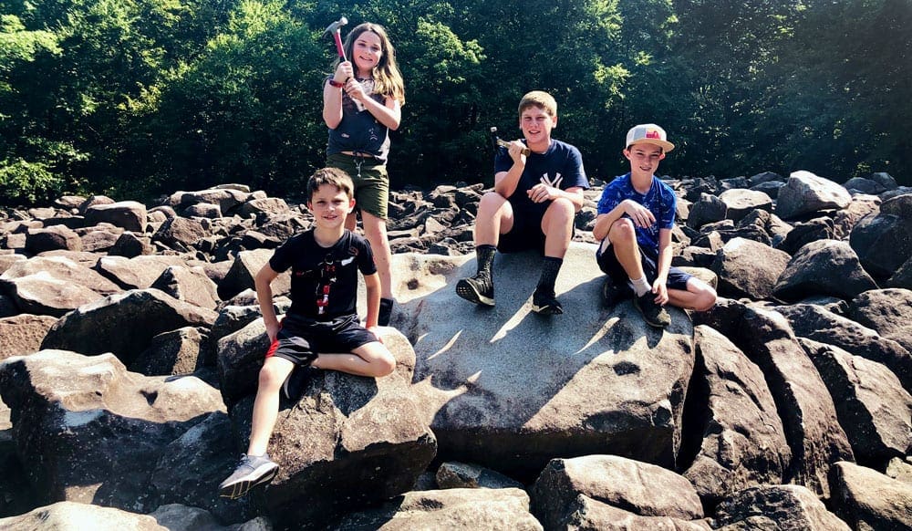 Group of kids sitting on the rocks holding hammers in New Hope PA