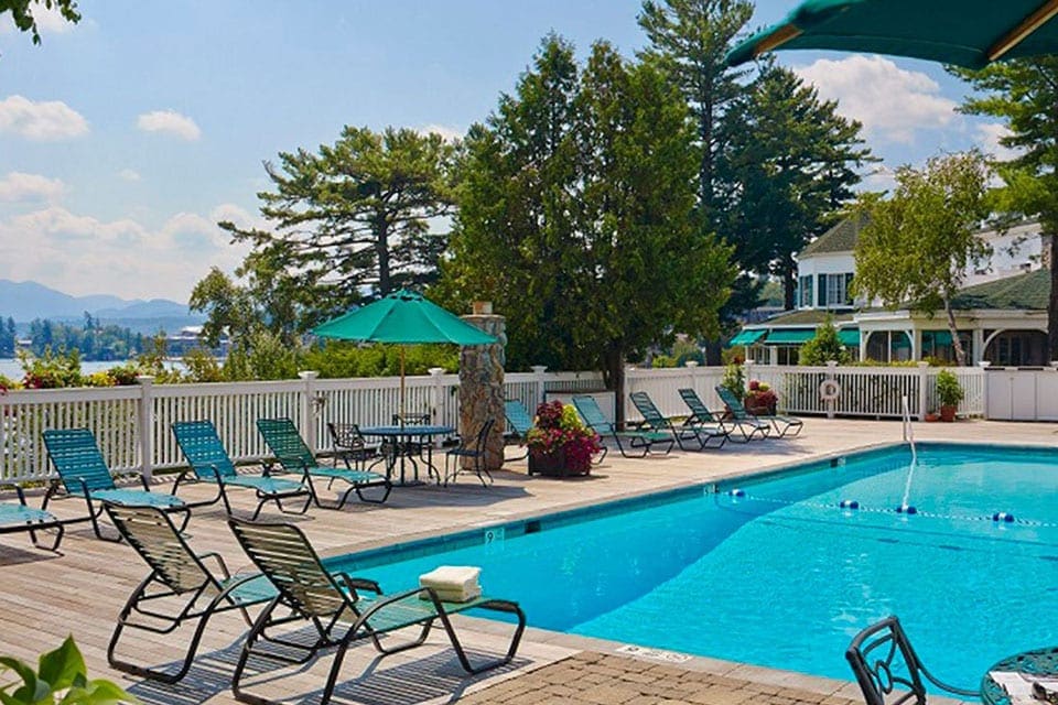Outdoor pool flanked by several lounge chairs at Mirror Lake Inn Resort & Spa.