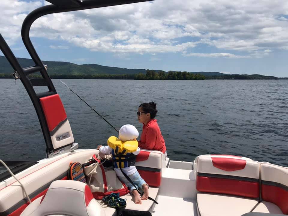 Mother and son fishing on boat in Lake George, one of the best places to stop on an NYC to Niagara Falls itinerary for families. 