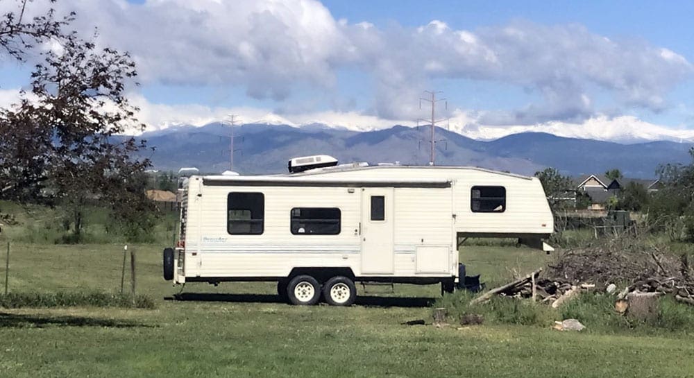 A white RV parked near the mountains.