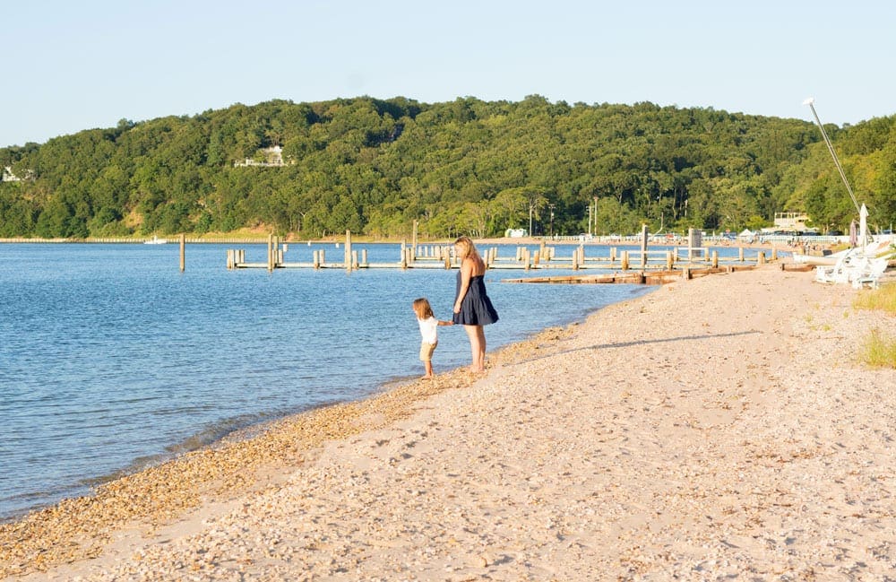 Mom is a black dress with a little boy on Shelter Island beach, one of the best family beach trips near NYC.