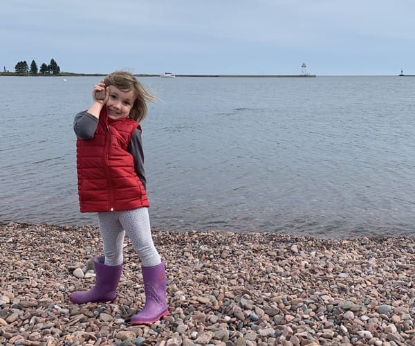 Little girl on a pebble beach of Lake Superior in Minnesota.