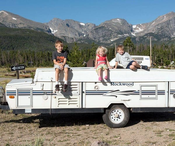 Three kids sitting in a trailer-Family RVing