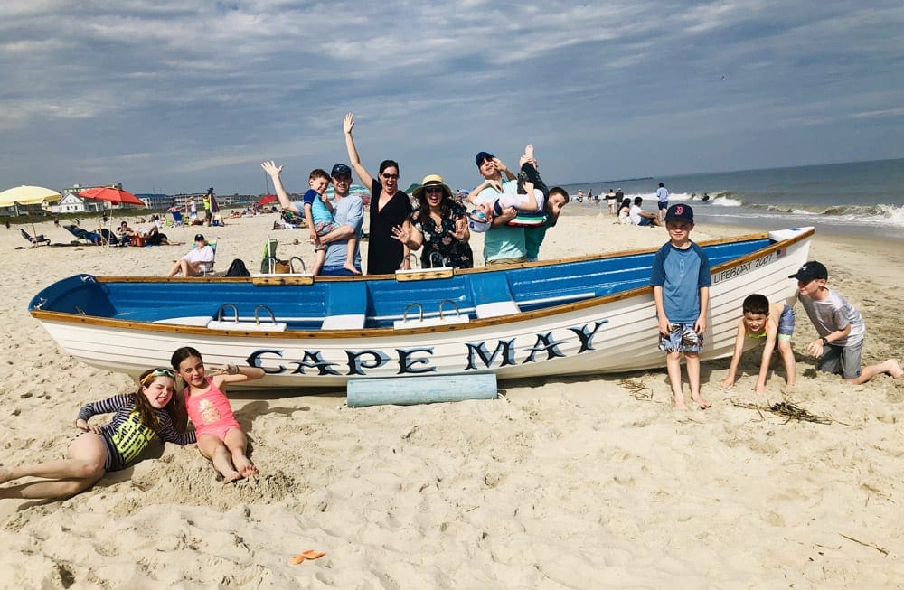 Huge Family posing with a boat saying Cape May, one of the best family beach trips near NYC.