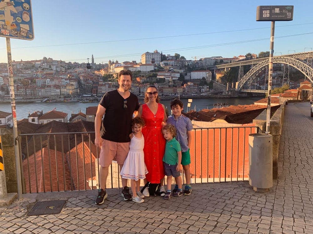 Family posing for photos in Porto, overlooking a view of the city.