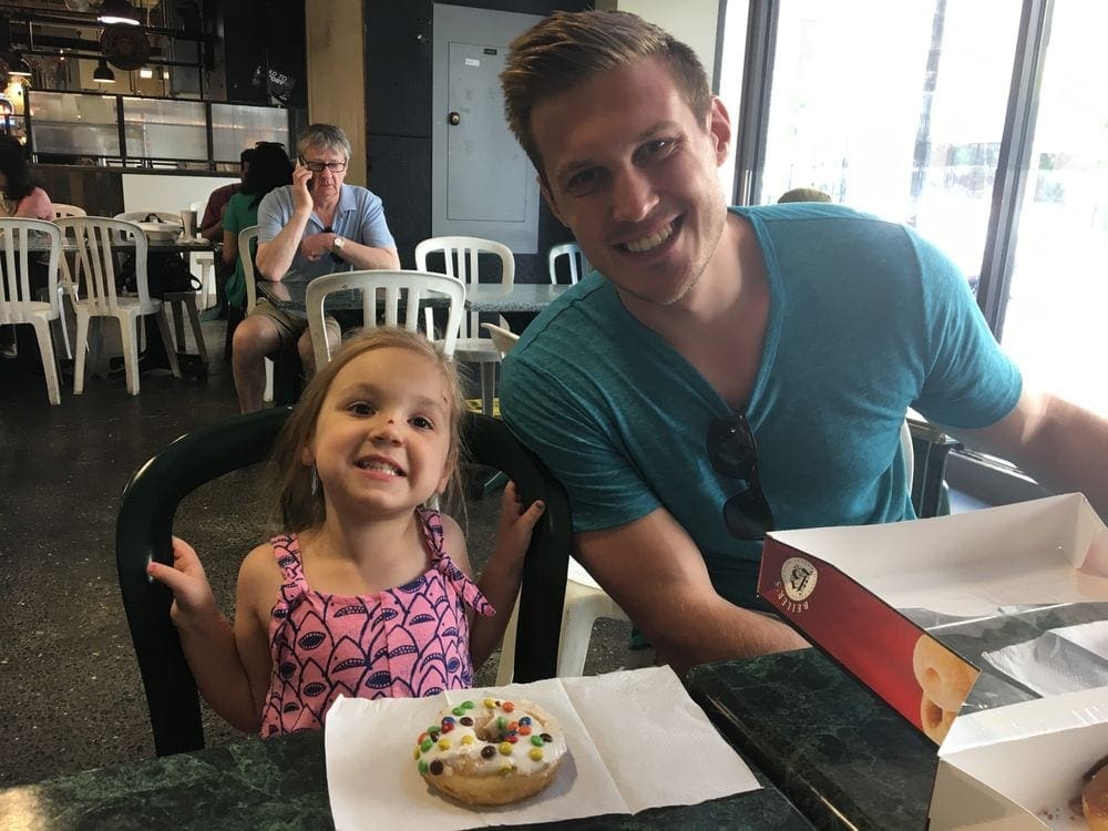 Uncle and Child enjoying a doughnut in Philadelphia's Reading Market, one of the best Philadelphia attractions for families.