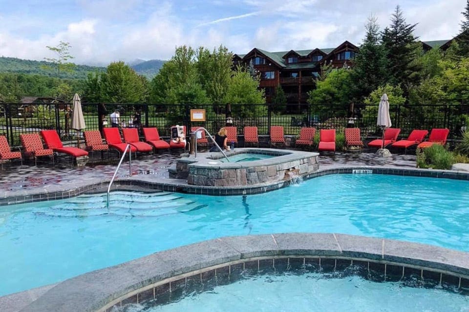 The pool at the Whiteface Lodge, surrounded by red lounge chairs.