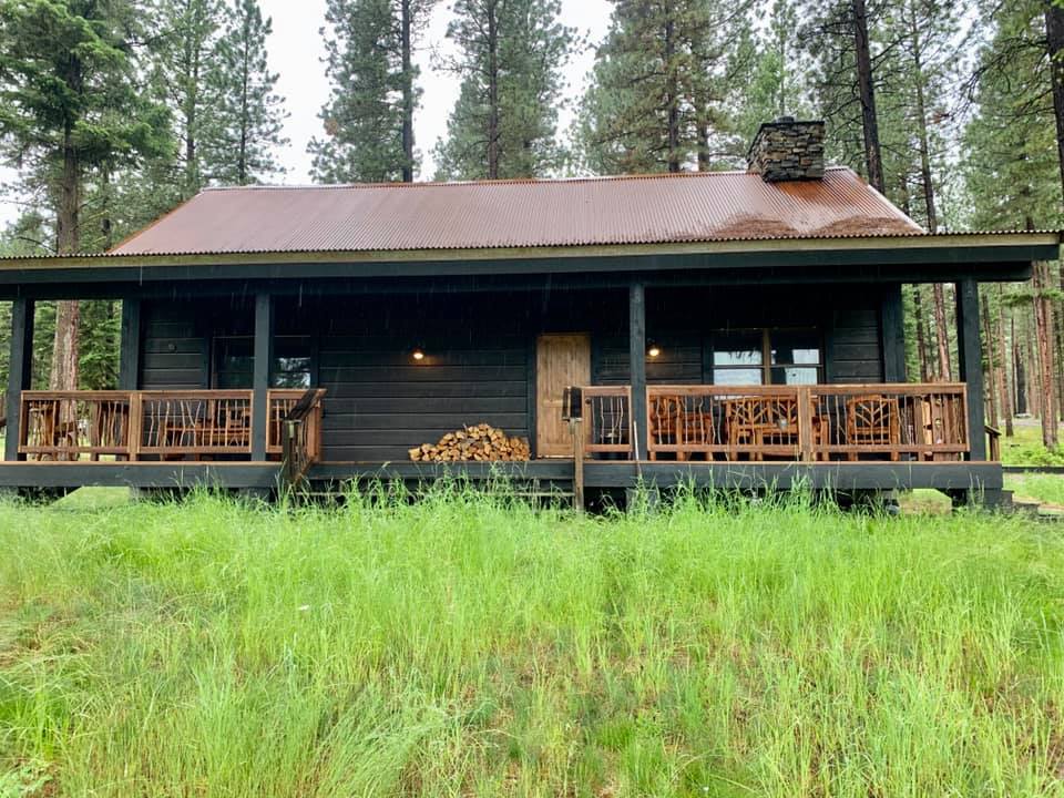 A cabin sits withing a grassy field.