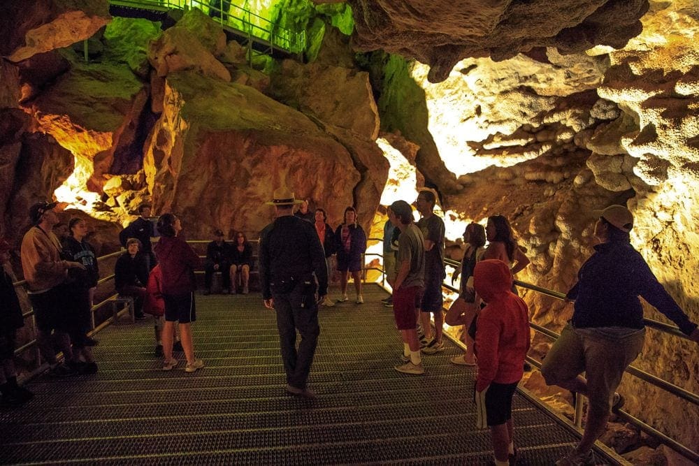 A large group gathers insdie the Jewel Cave in South Dakota while on a tour inside the cave. Families should consider a cave tour when on their Black Hills vacation with kids.