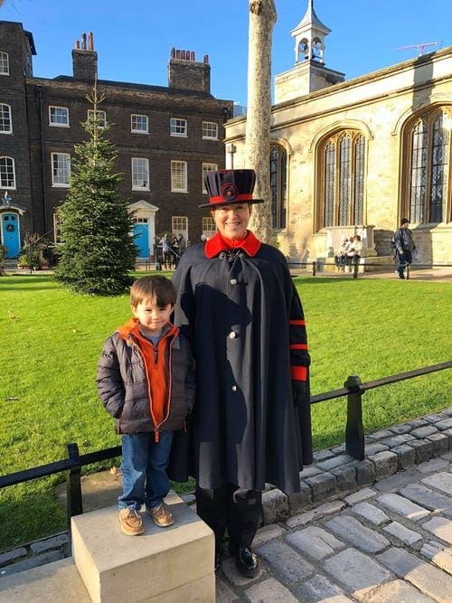 A young boy stands with a British schoolmaster near London.