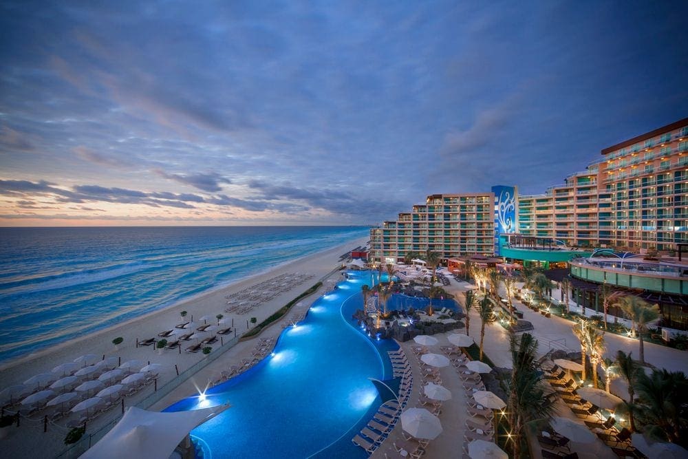 An expansive view of the Hard Rock Hotel Cancun, including the building, pool, beach, and ocean.
