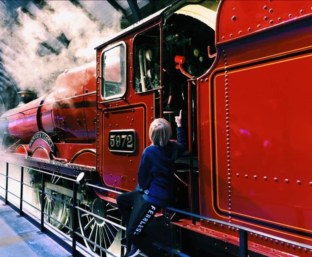 A young boy looks into the Hogwarts Express, on display at the Warner Bros. studio in London.