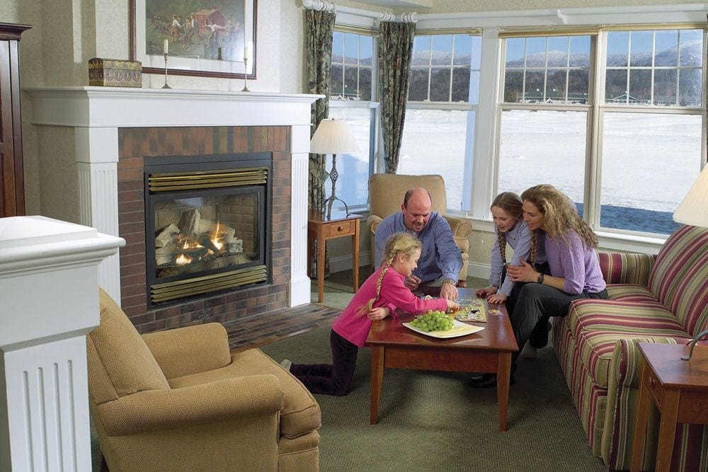 In a pleasent setting within Stoweflake Mountain Resort & Spa, a family of four enjoys a boardgame with some snacks.