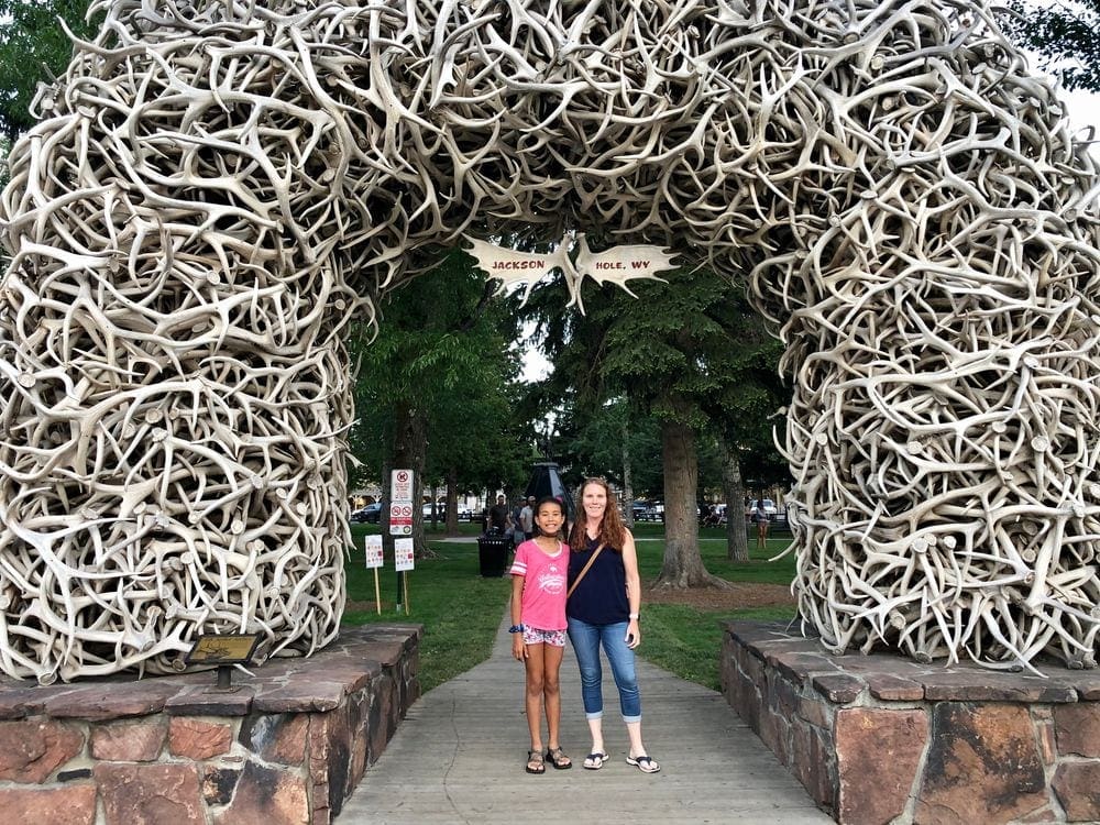 A mom and her pre-teen daughter stand in front of Jackson's iconic entrance created with fallen antlers.