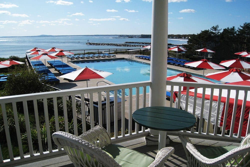 Nestled amongst red and white umbrellas is the pristine outdoor pool at The Colony Hotel, one of the best beach resorts in the Northeast for families.