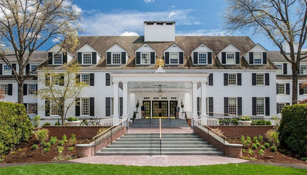 The front entrance of the large, white building housing the main part of the Woodstock Inn & Resort, one of the best Vermont hotels for families.