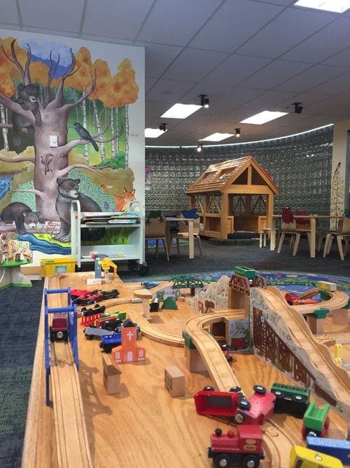 A colorful library in Vail, featuring train toys and woodland creatures.